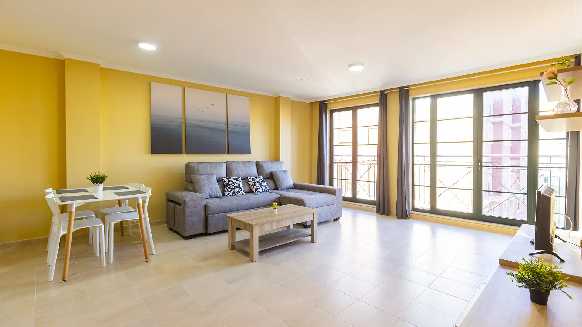 Salón luminoso del apartamento Batel de Apartagal en Foz, con sofá gris, mesa de comedor y balcón